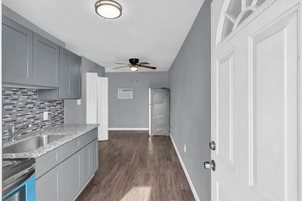 a view of a kitchen with a sink wooden floor and cabinets