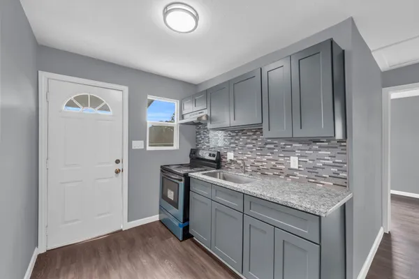 a kitchen with a sink stove and cabinets