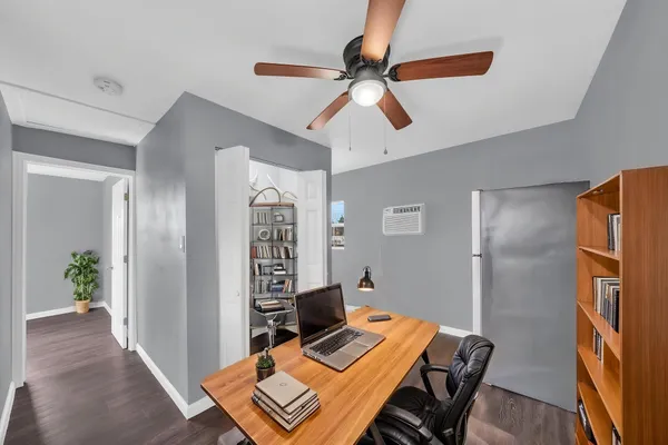 a view of a workspace with furniture and a window