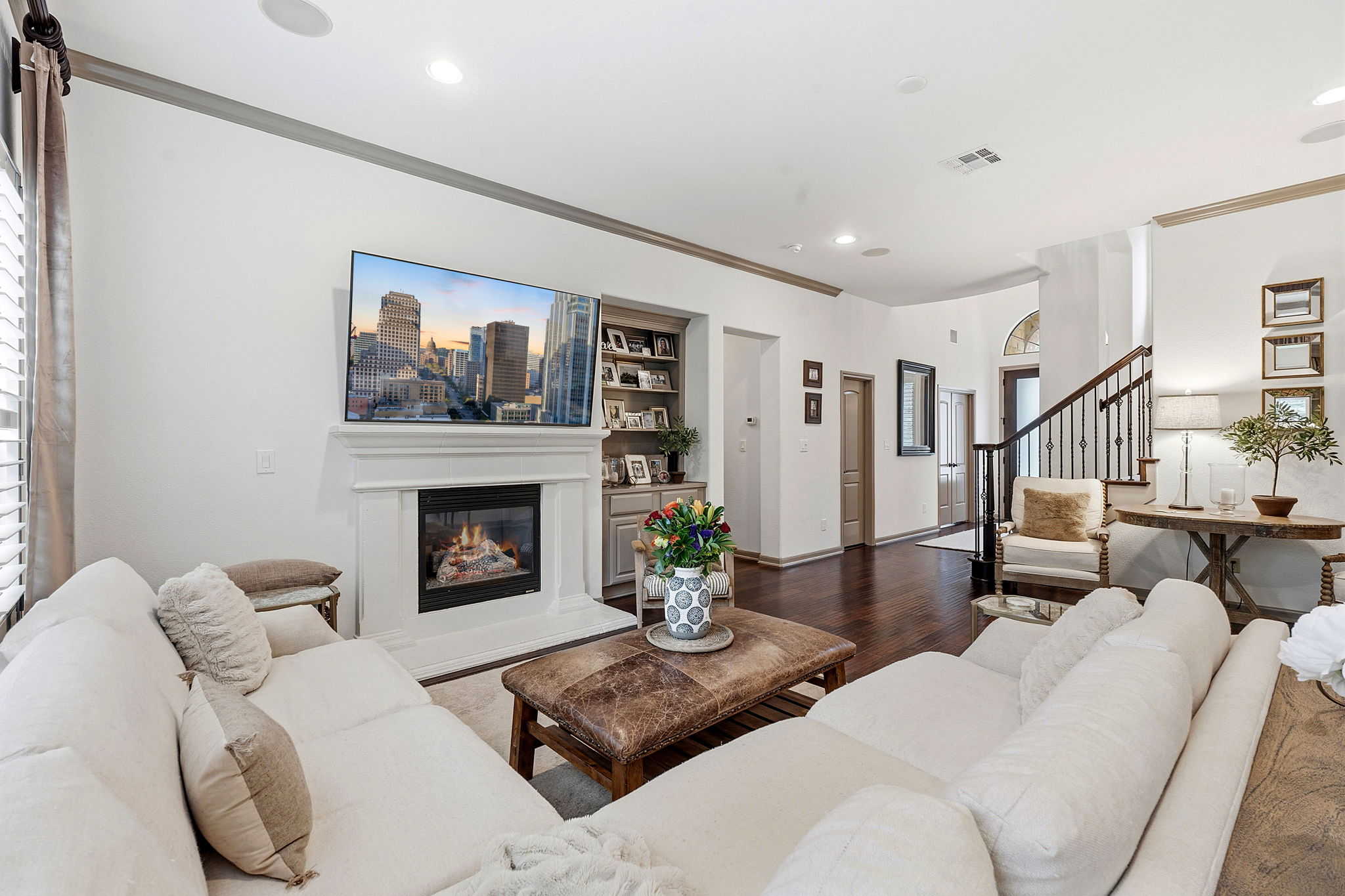 12321 Edenvale Path Austin, TX 78732 - Photo 3 of 36 Warm hardwood floors and a cozy fireplace create an inviting atmosphere in this grand living area.