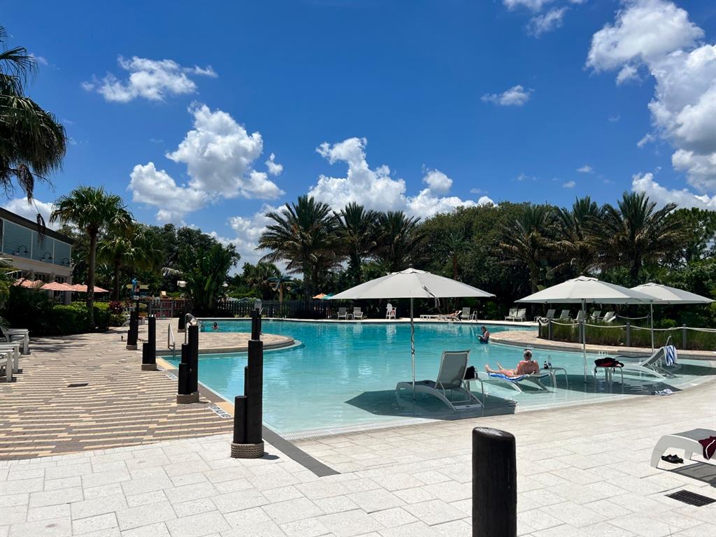 955 Conch Road Davenport, FL 33896 - Photo 18 of 20 a view of swimming pool with lawn chairs under an umbrella