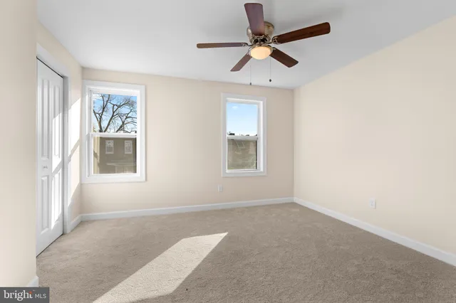 an empty room with a window and a ceiling fan