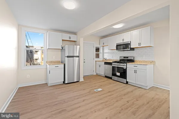 a kitchen with white cabinets and stainless steel appliances
