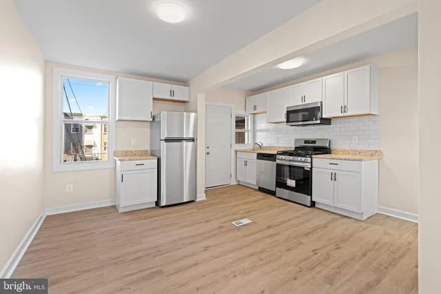 a kitchen with white cabinets and stainless steel appliances