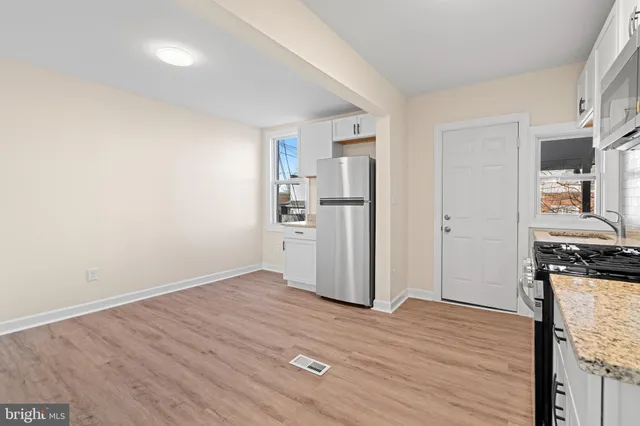 a kitchen with stainless steel appliances granite countertop a refrigerator and a stove top oven