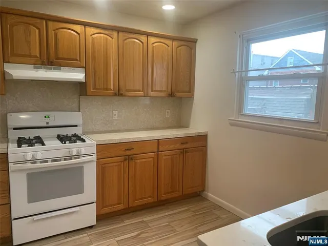 a kitchen with stainless steel appliances granite countertop a refrigerator a stove and a sink with cabinets