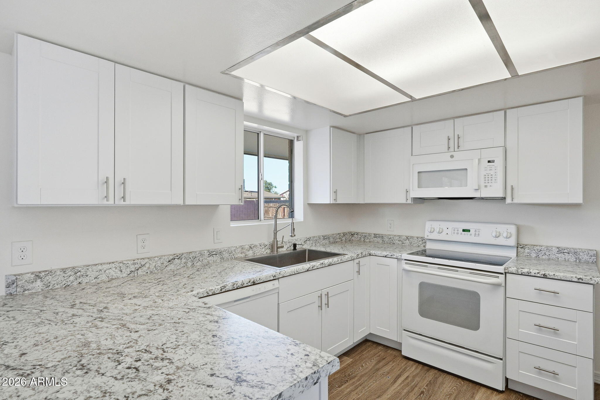 2302 East Nisbet Road Phoenix, AZ 85022 - Photo 5 of 22 a kitchen with granite countertop white cabinets and white appliances