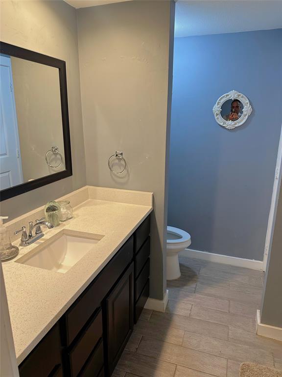 7340 Skillman Street, Unit 1203 Dallas, TX 75231 - Photo 5 of 12 a bathroom with a sink a toilet and a mirror