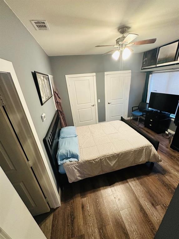 7340 Skillman Street, Unit 1203 Dallas, TX 75231 - Photo 8 of 12 a bedroom with a bed and wooden floor