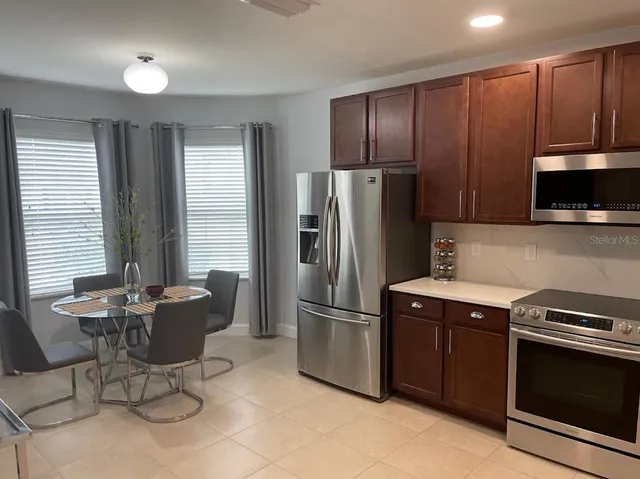 a kitchen with stainless steel appliances granite countertop a refrigerator stove and microwave