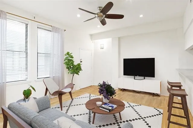 a living room with furniture a flat screen tv and a large window