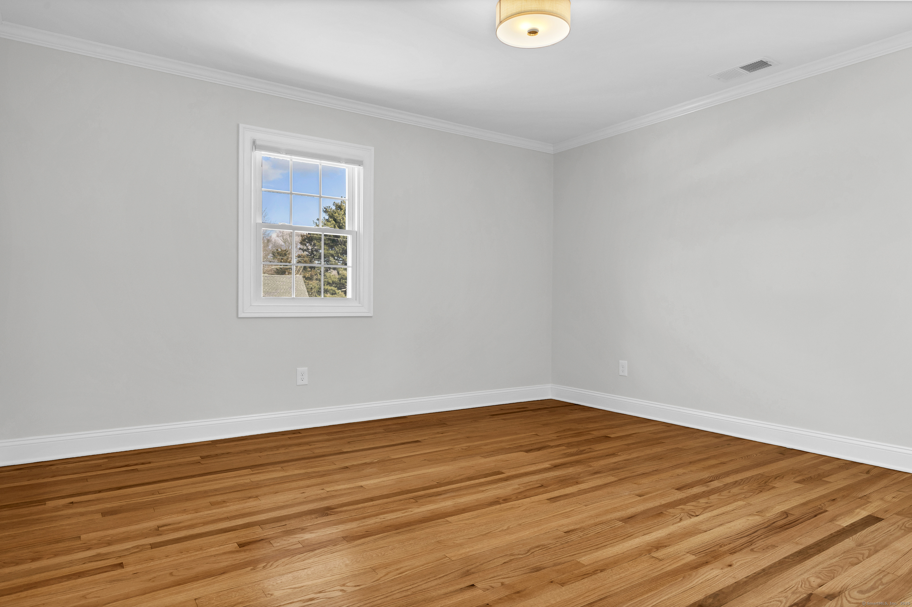 122 North Street, Unit 4 Guilford, CT 06437 - Photo 16 of 22 a view of an empty room with wooden floor and a window