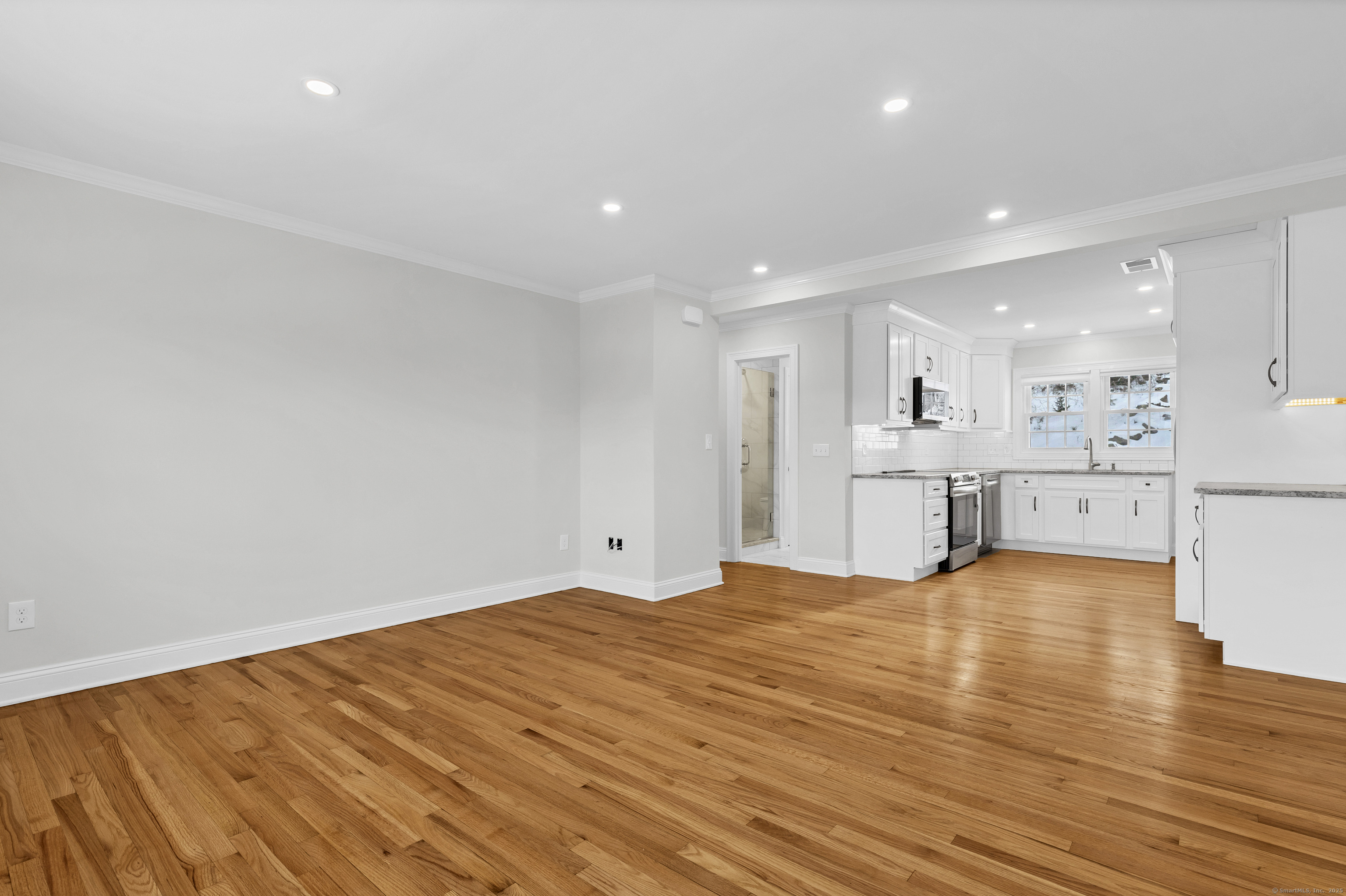 122 North Street, Unit 4 Guilford, CT 06437 - Photo 9 of 22 a view of an empty room with wooden floor and kitchen