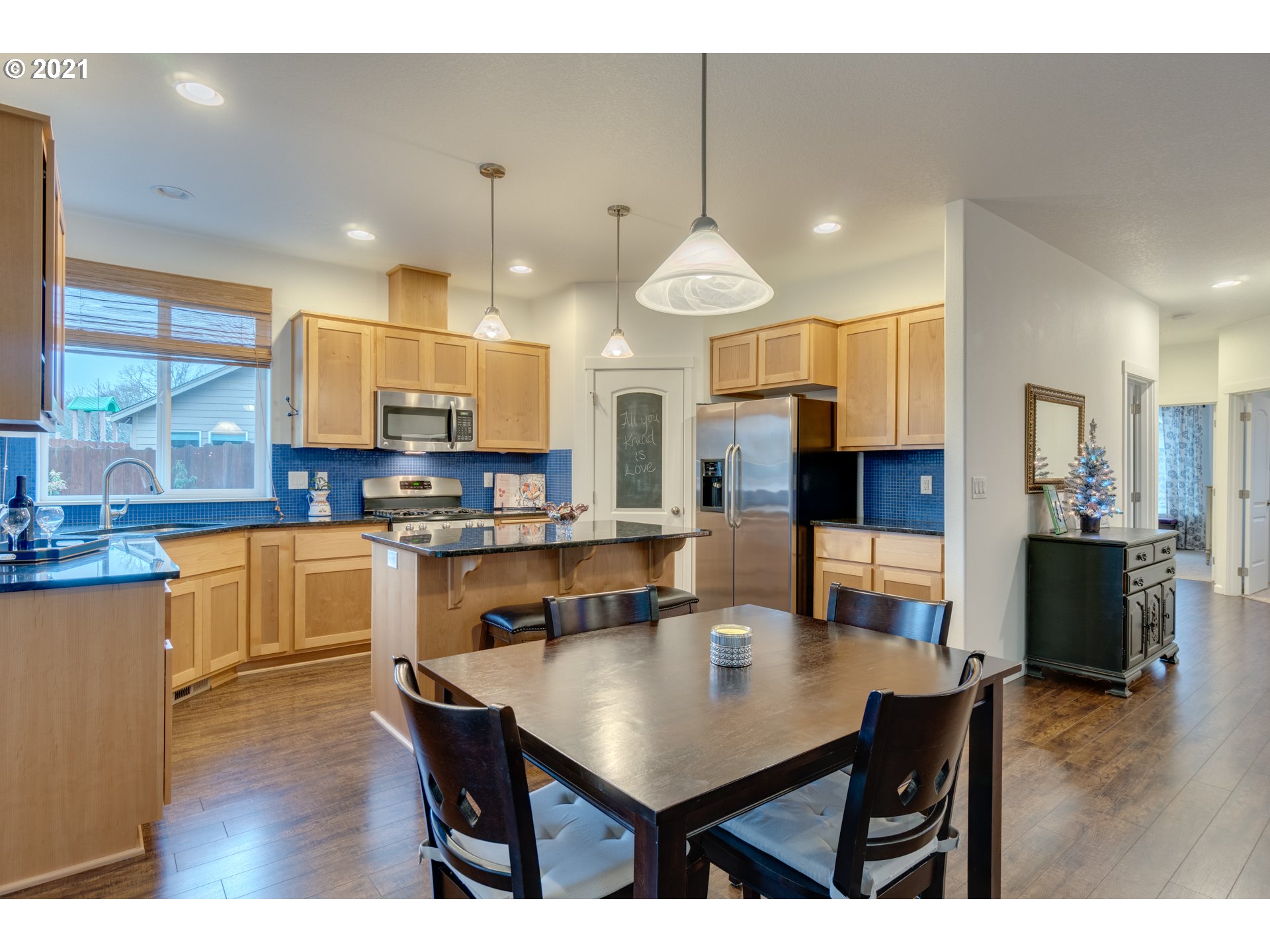 2609 South 18th Court Ridgefield, WA 98642 - Photo 9 of 26 a kitchen with stainless steel appliances kitchen island granite countertop a table chairs and a refrigerator
