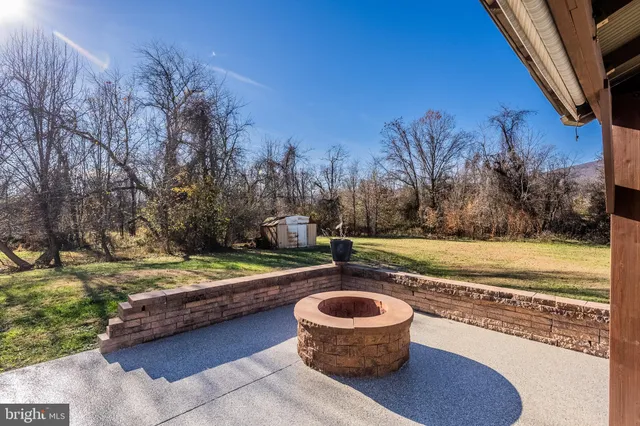 a view of a fire pit with plants and water view