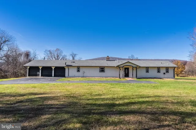 a view of a livingroom with wooden floor and a fireplace