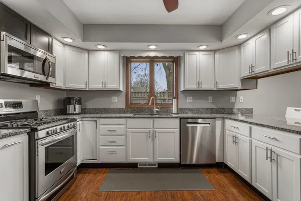 a kitchen with stainless steel appliances granite countertop a stove sink and cabinets