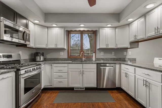 a kitchen with stainless steel appliances granite countertop a stove sink and cabinets