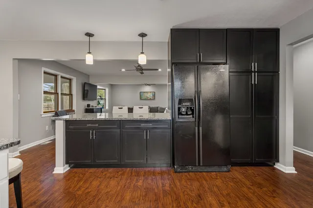 a kitchen with stainless steel appliances granite countertop a refrigerator and a sink