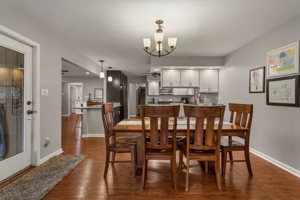 a view of a dining room with furniture a chandelier and wooden floor