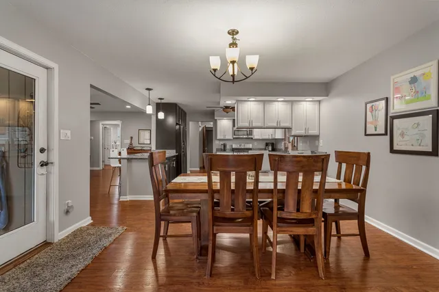 a view of a dining room with furniture a chandelier and wooden floor