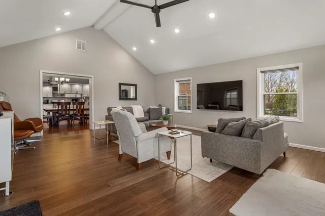 a living room with furniture a flat screen tv and wooden floor
