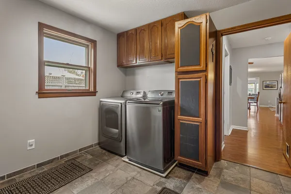 a view of a kitchen with refrigerator and wooden cabinets