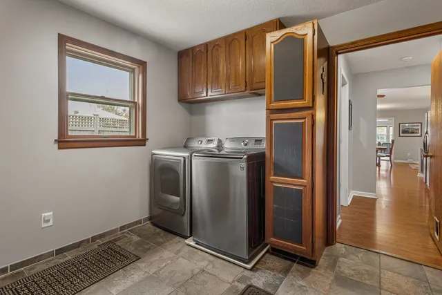 a view of a kitchen with refrigerator and wooden cabinets