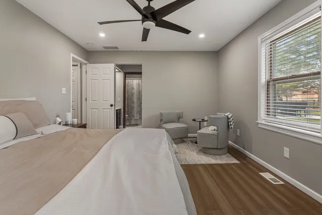 a spacious bedroom with a bed and glass window