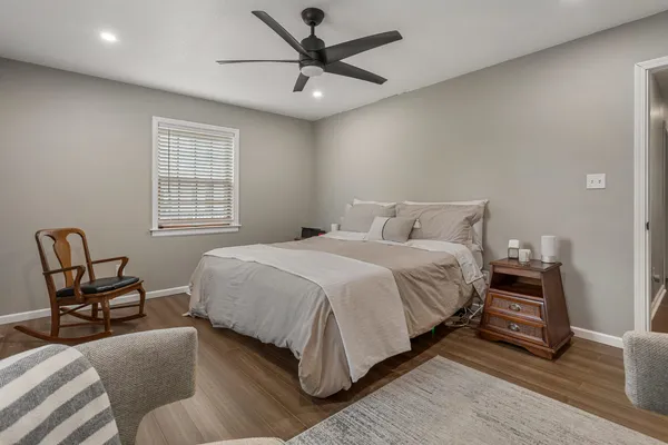 a bedroom with a bed chair and window