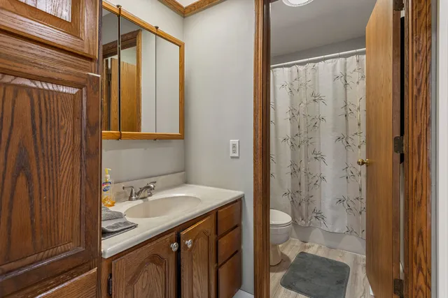 a bathroom with a granite countertop sink toilet and shower