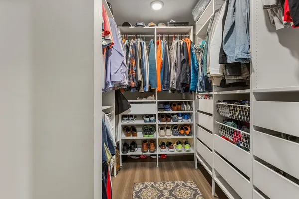 a view of walk in closet with clothes and shoes