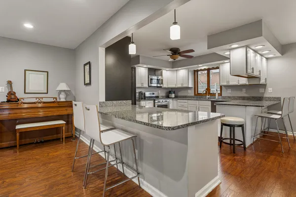 a kitchen with granite countertop a sink appliances and cabinets