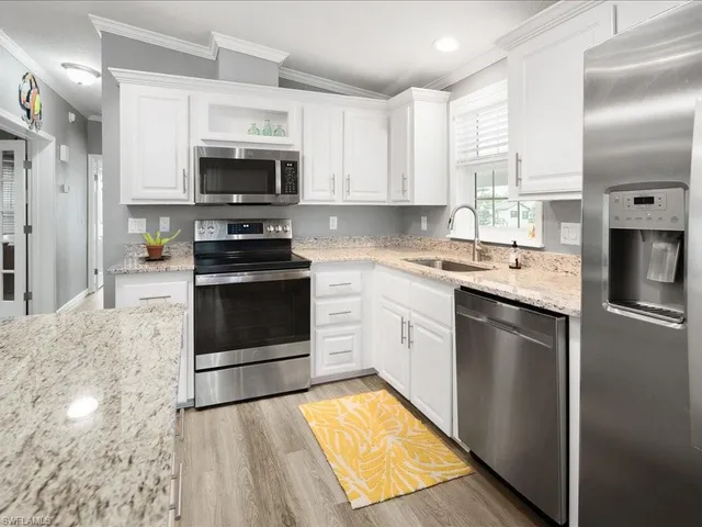 a kitchen with stainless steel appliances granite countertop a stove a sink and a microwave