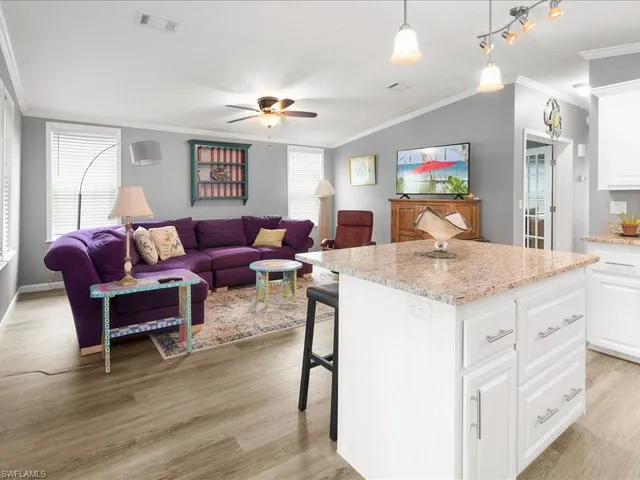 a living room with granite countertop furniture and a wooden floor
