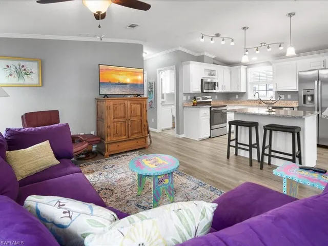 a living room with furniture and kitchen view