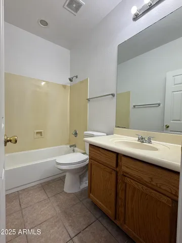 a bathroom with a double vanity sink toilet mirror and bathtub