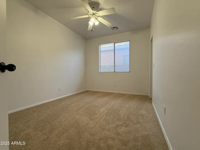 an empty room with a window and a fan