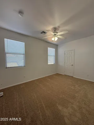 an empty room with windows and fan