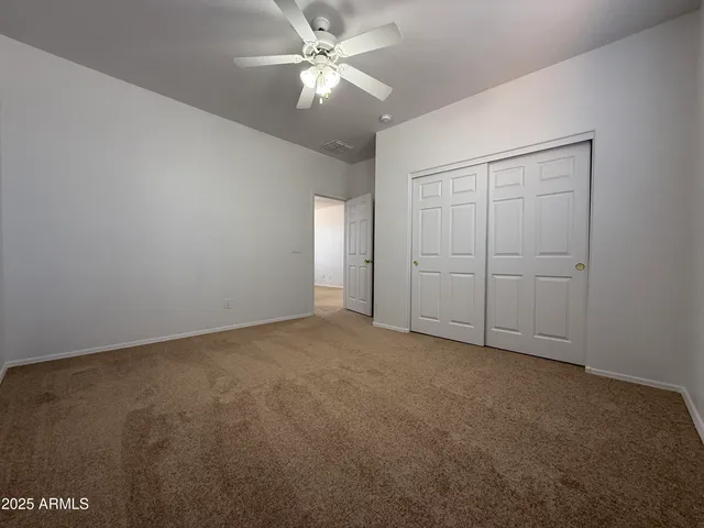 an empty room with chandelier fan