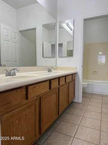 a spacious bathroom with a sink a mirror and a bathtub