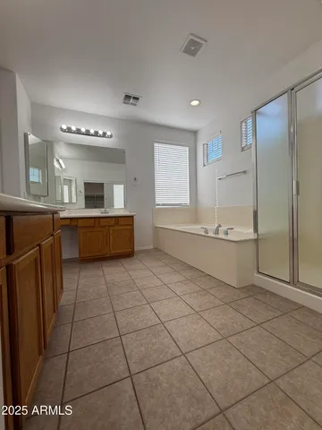 a large white room with a large mirror and cabinets