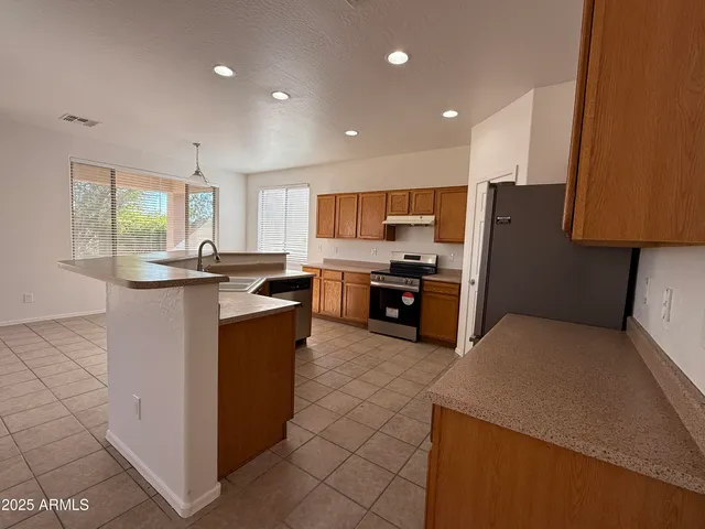 a kitchen with stainless steel appliances granite countertop a refrigerator and a stove