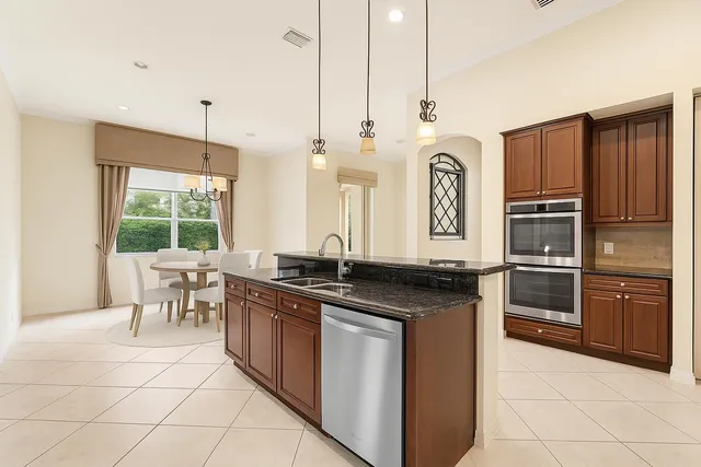 a kitchen with stainless steel appliances granite countertop a stove a sink and a refrigerator