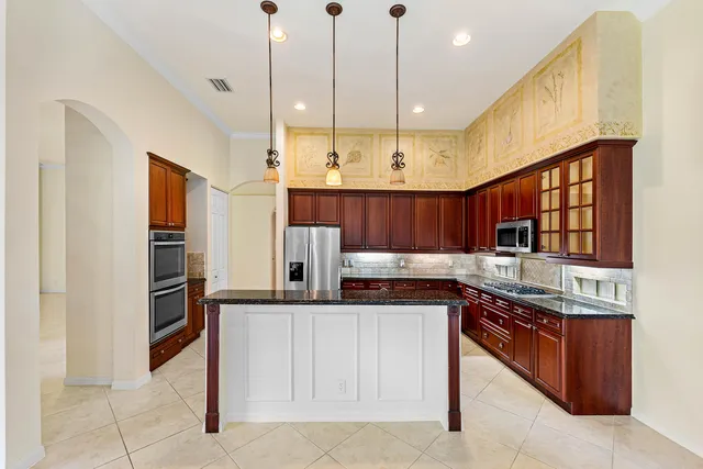 a kitchen with stainless steel appliances kitchen island granite countertop a sink and cabinets