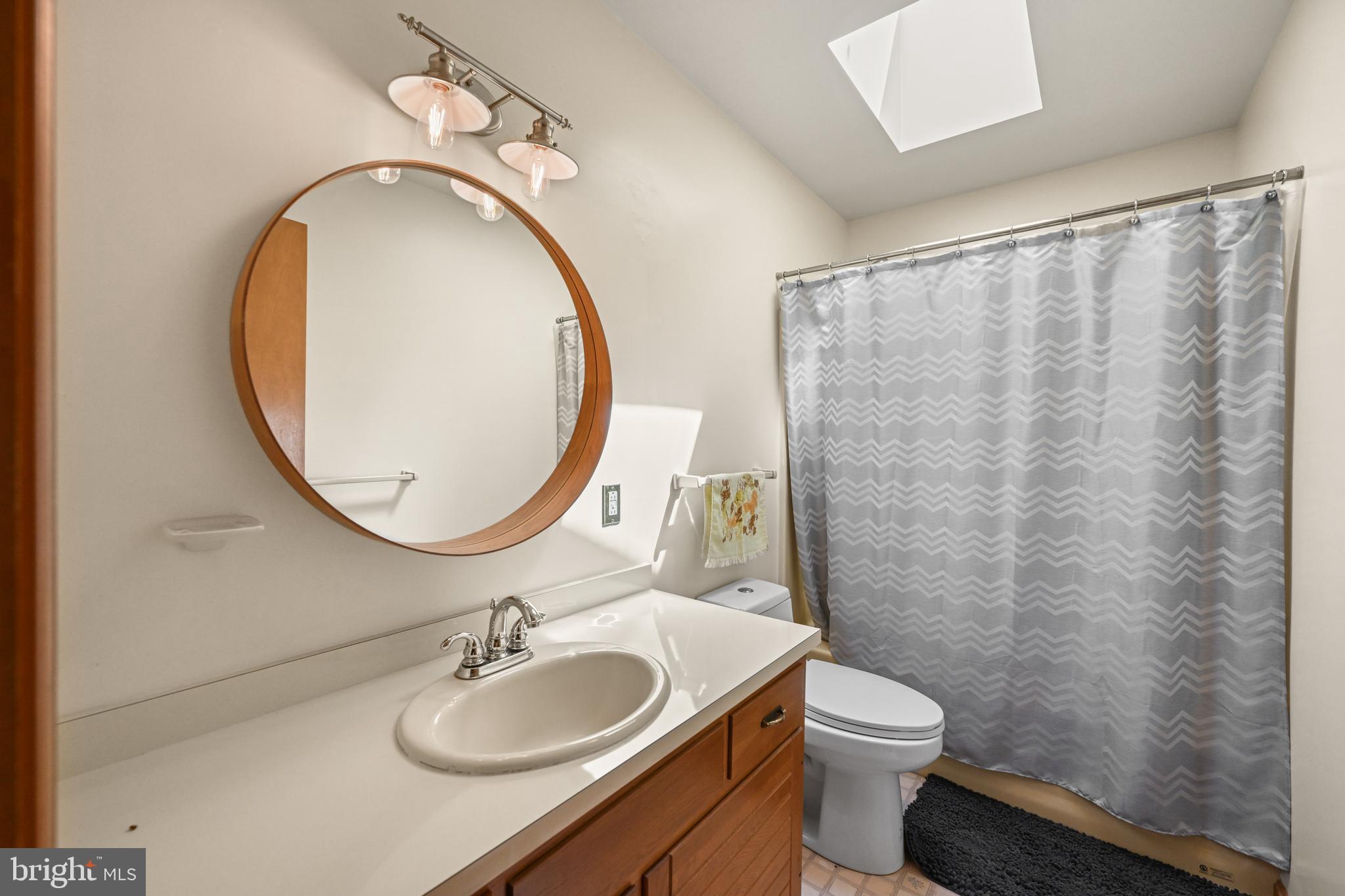 1680 East Street Road Kennett Square, PA 19348 - Photo 21 of 30 a bathroom with a granite countertop sink a toilet and a mirror