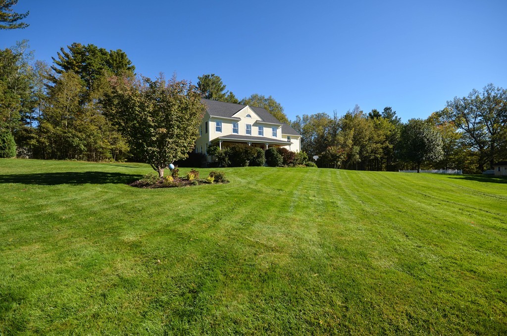 66 Barnett Road Sutton, MA 01590 - Photo 1 of 30 a view of a green field with house in the background