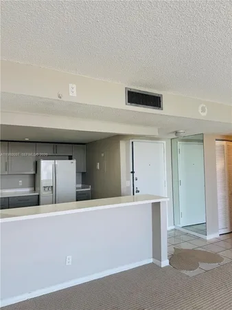 a kitchen with kitchen island a sink and a refrigerator