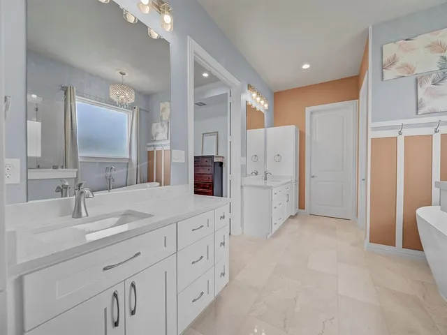 a spacious bathroom with double sink and a mirror