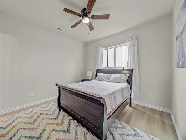 a bedroom with a bed and a ceiling fan